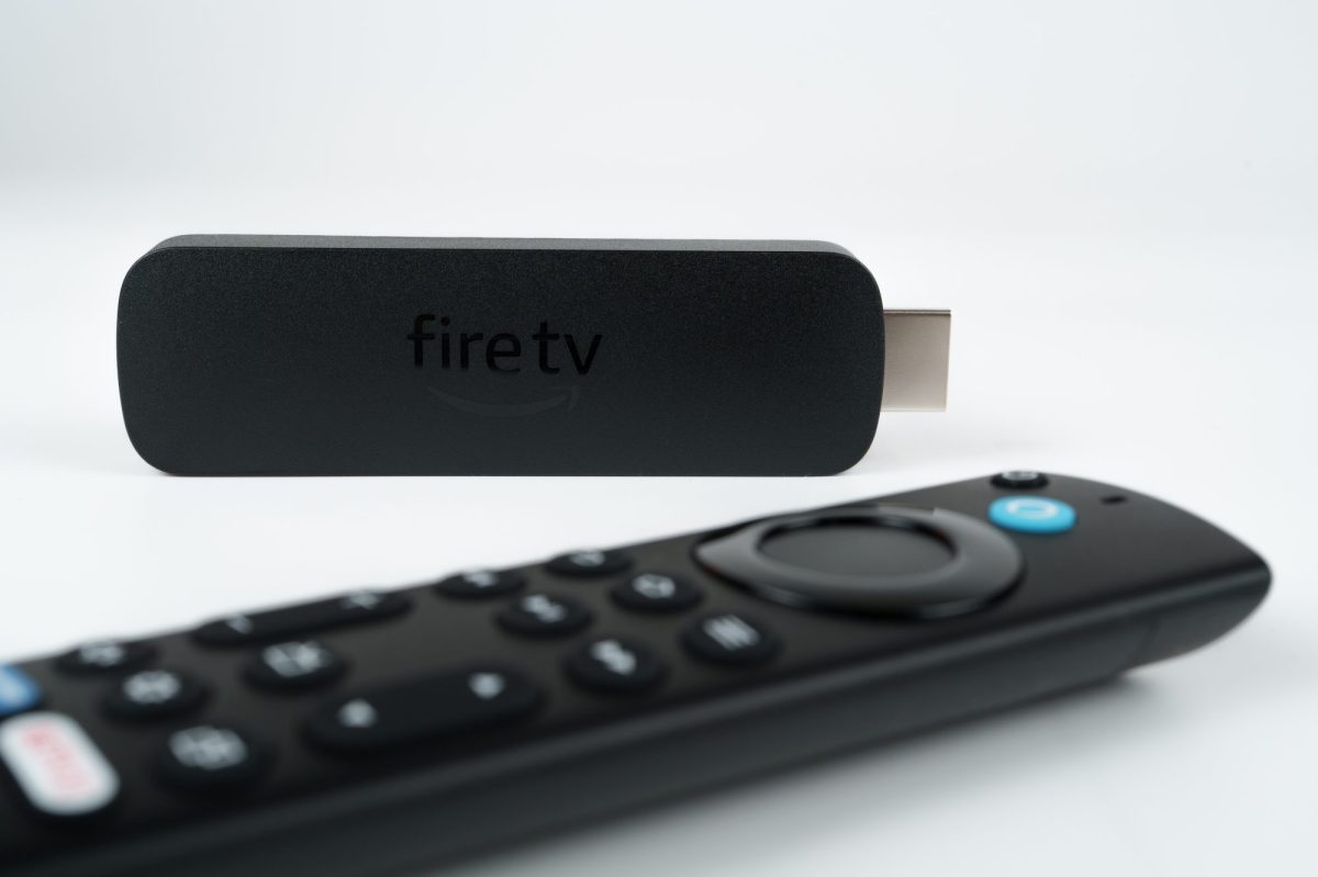 Amazon Fire TV Stick liegt neben einer Fernbedienung.