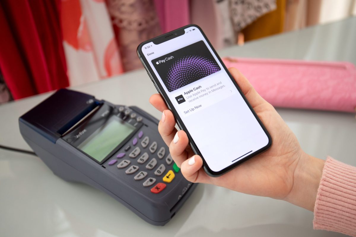 Person bezahlt mit Apple Pay via Smartphone.