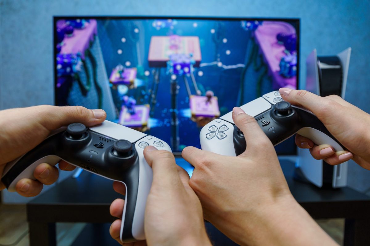 Personen halten PS5-Controller in der Hand und spielen.