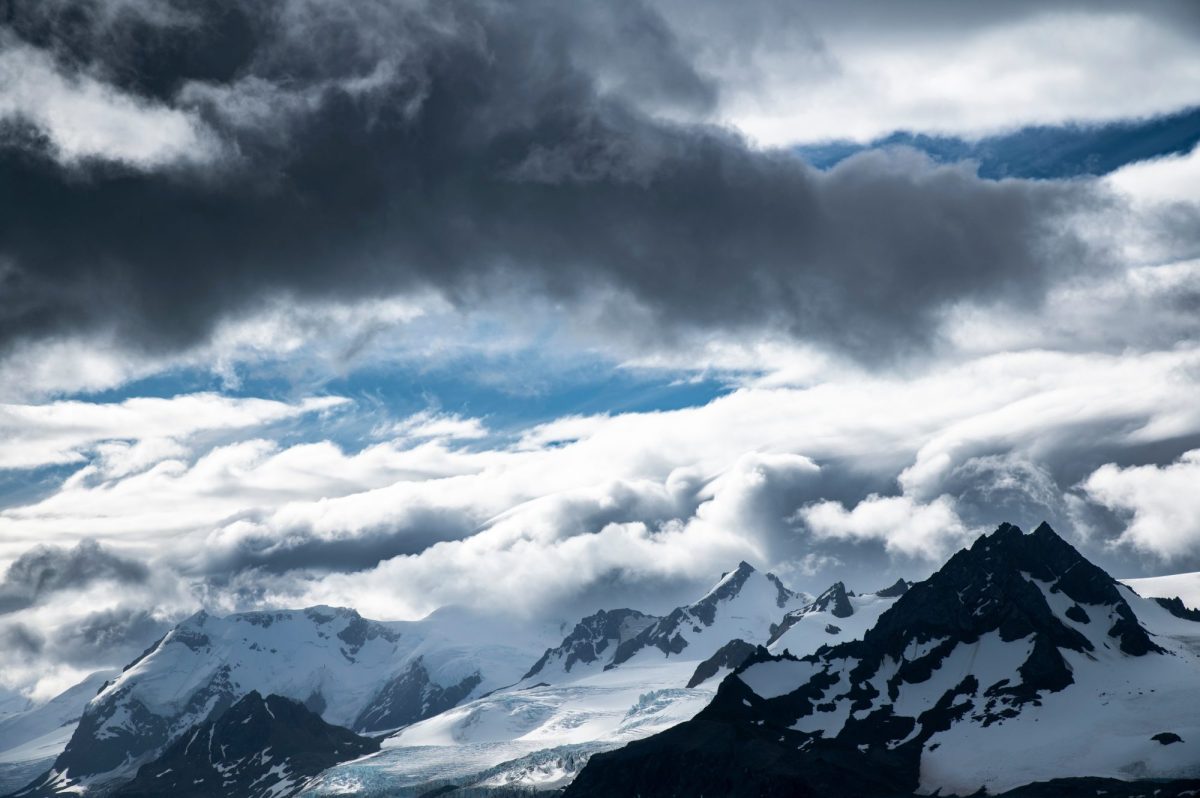 Wolken Ã¼ber schneebedeckten Bergen.