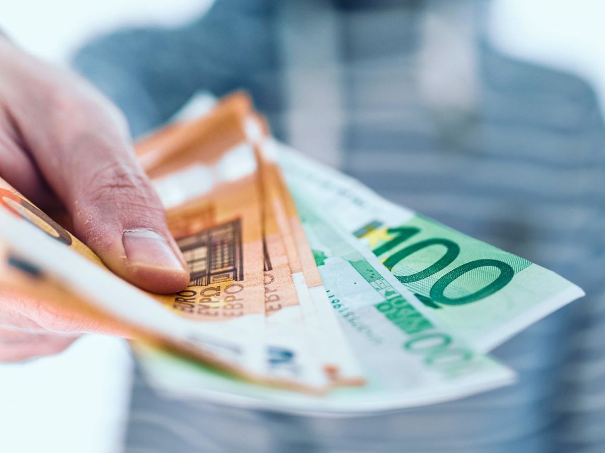 Mann hÃ¤lt Bargeld in der Hand