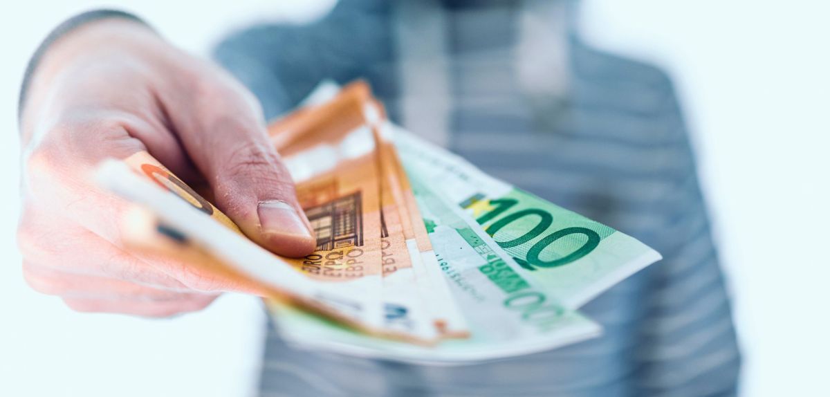 Mann hÃ¤lt Bargeld in der Hand