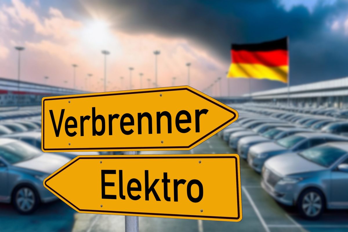 Zwei Verkehrsschilder, die in unterschiedliche Richtungen deuten. Auf einem Steht Verbrenner, auf dem anderen Elektro. Im Hintergrund stehen geparkte Autos.