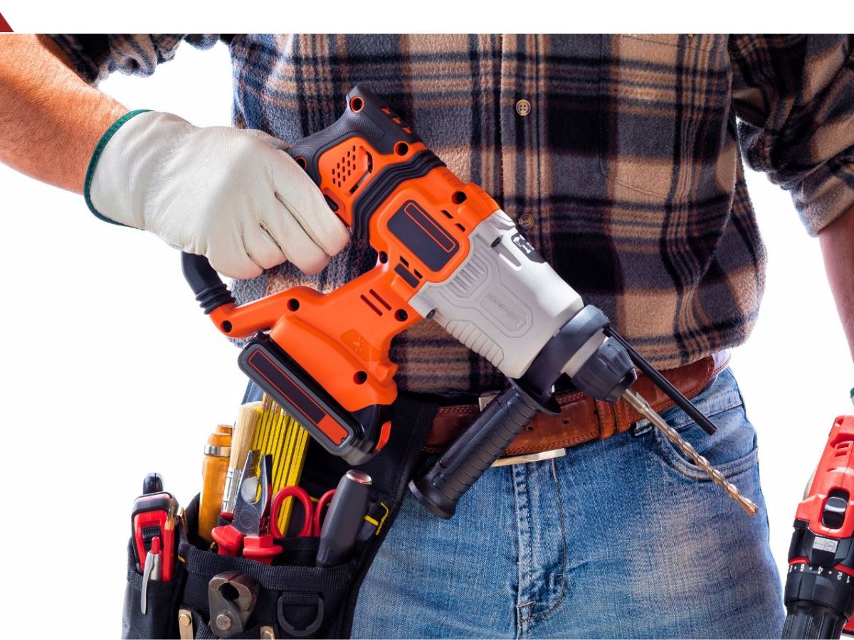 Eine Person mit WerkzeuggÃ¼rtel hÃ¤lt einen Akku-Bohrhammer in der Hand.