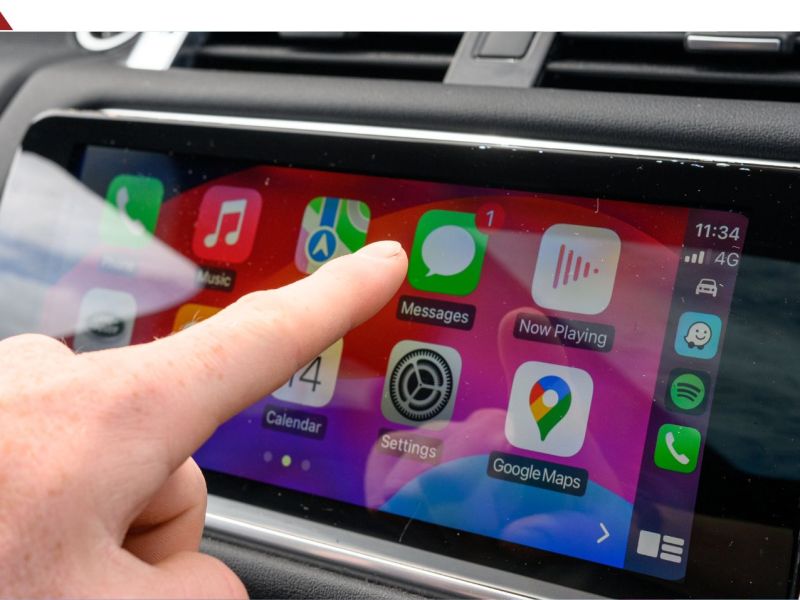 Person bedient einen Auto-Display mit Apple Carplay