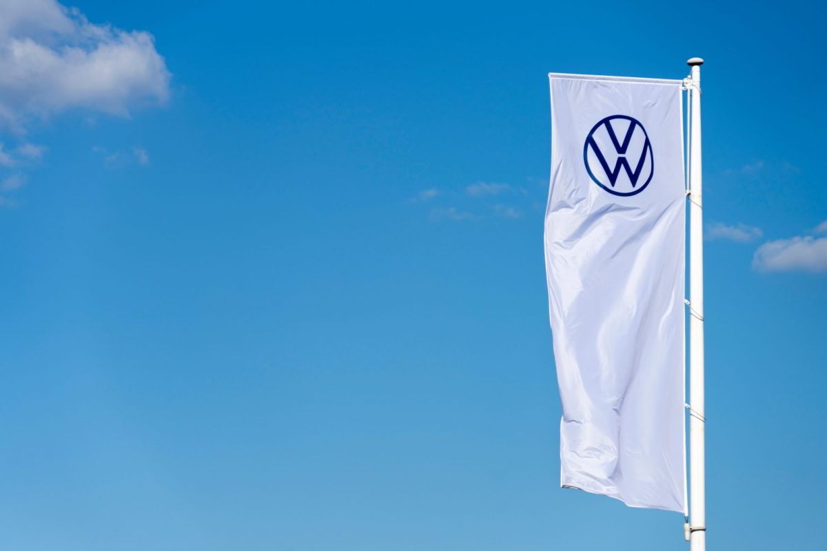 WeiÃŸe Fahne mit VW-Logo vor blauem Himmel.