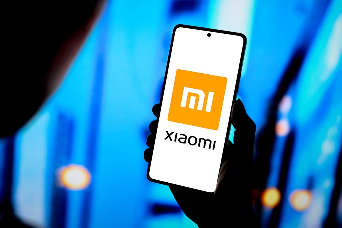 Person hÃ¤lt ein Smartphone in der Hand, auf dem Display ist das Xiaomi-Logo.